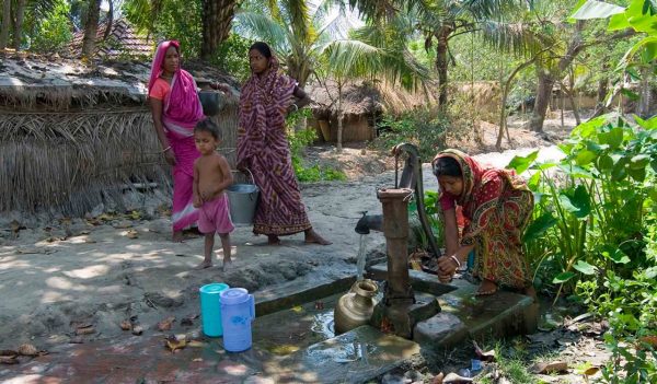 A woman getting water from a tap