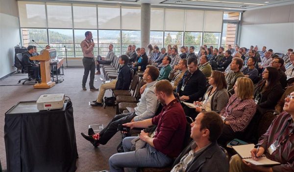 People in a room listening to a person presenting