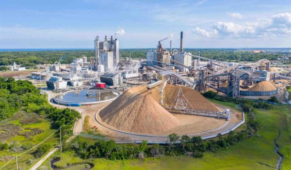 Aerial view of a paper mill with the waste pile and a water treatment tank.