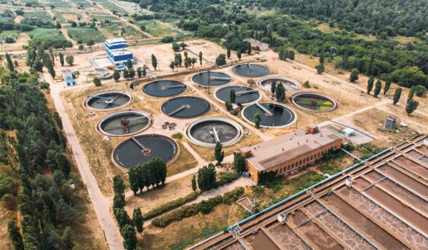 Aerial view of wastewater treatment plant showing the tanks in the ground.