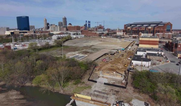 An aerial photo of Greenlawn Cemetery during excavation, with the city of Indianapolis and Lucas Oil Stadium in the background. 
