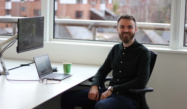 Scott Nicholson sitting at his desk with a window in the background.