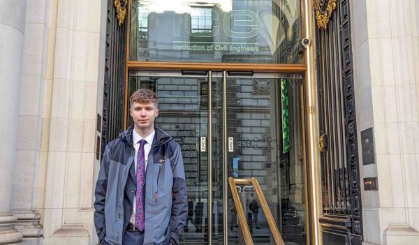 Vinnie Redfern standing in front of the Institute of Civil Engineers building entrance.