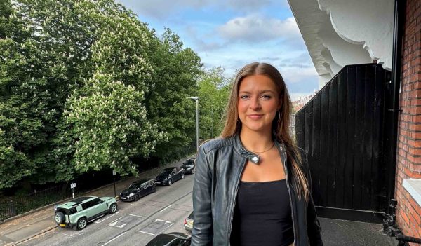 Maddy Nunan standing on a balconay with a roadway in the background.