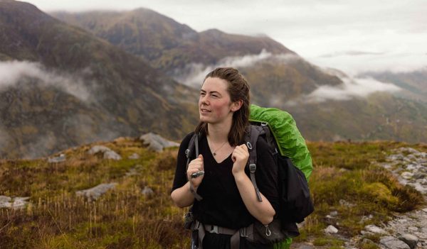 Ruby Stringer hiking, carrying a green backpack.