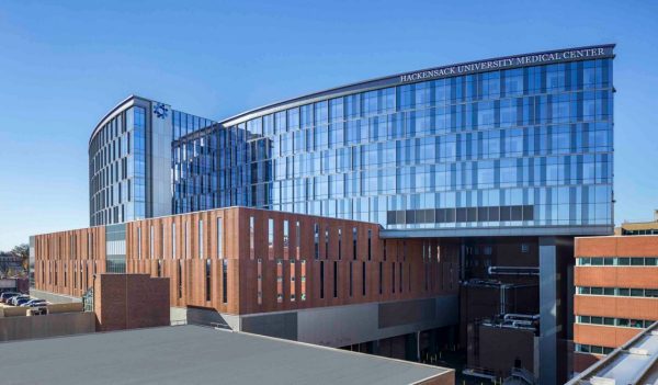 Buildig exterior with a curved glass wall section with the lower section of the building in brick.