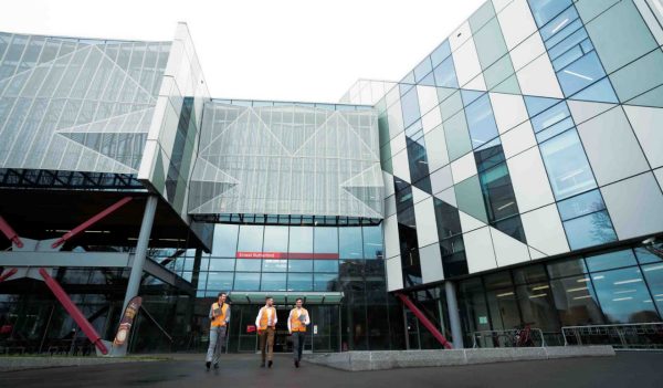 Building exterior with three people walking out of the front entrance.