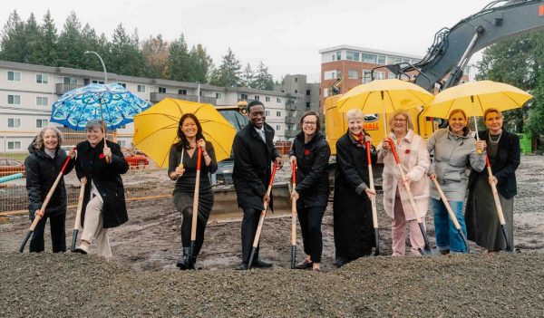 Goup image of dignitaries with shovels taking part in a ground breaking ceremony. 