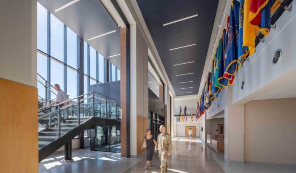 Interior double height corridor with stairs to upper floor and views to the outdoors