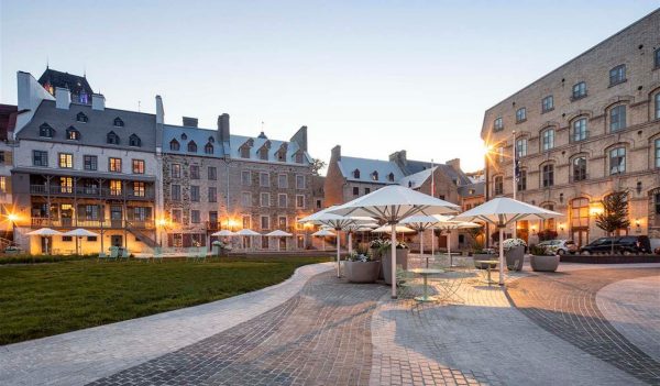 A grand hotel with a landscaped plaza in front