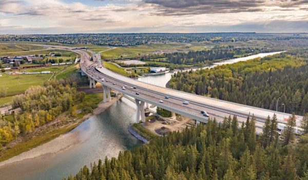 Overhead view of the Bridge over the Bow River with vehicles on the bridge and the city beyond