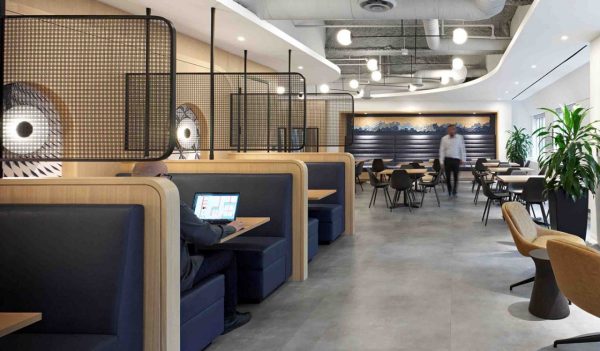 Interior employee meeting / cafe area with booths and tables in natural wood tones with blue accents.