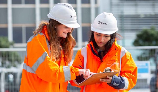 Stantec staff with hardhats and safety gear standing in front of a building