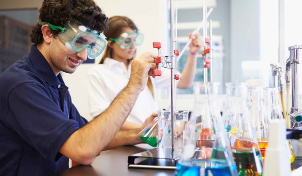 Pupils Carrying Out Experiment In Science Class